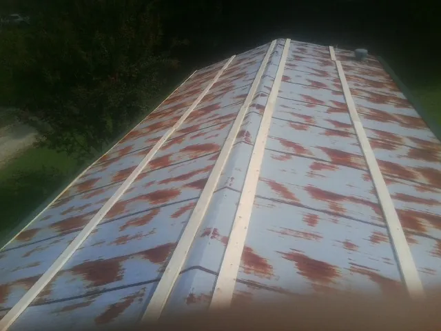 Rusted metal roof panels with new wood purlins before replacement — Storm Damage Roof Repair in Alexander City by Roofing Brothers
