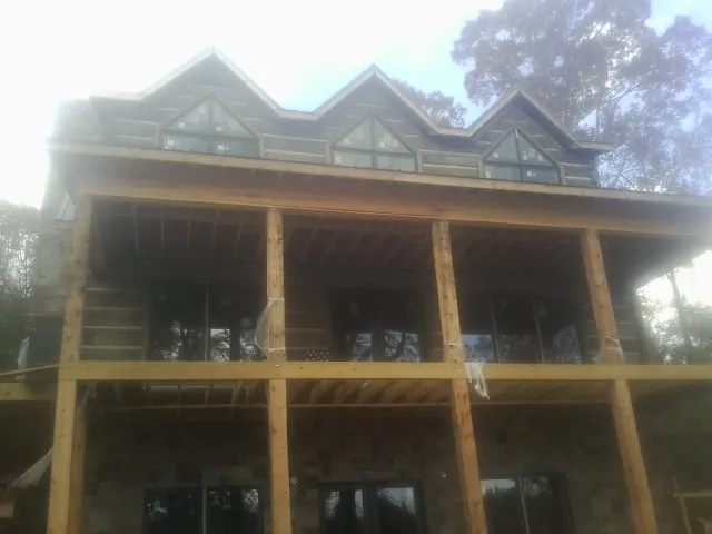 Dormers and porch framing on a large log home under construction — Roof Coating work by our crew in Alexander City