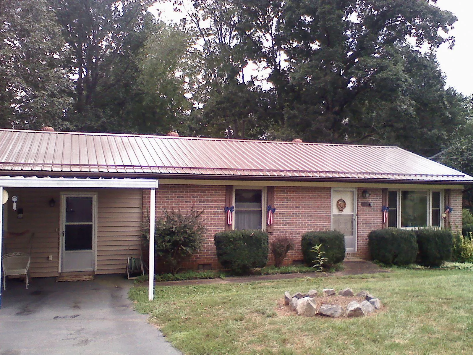 Bronze metal roof and carport on a brick ranch home — Roof Repair work by our crew in Alexander City