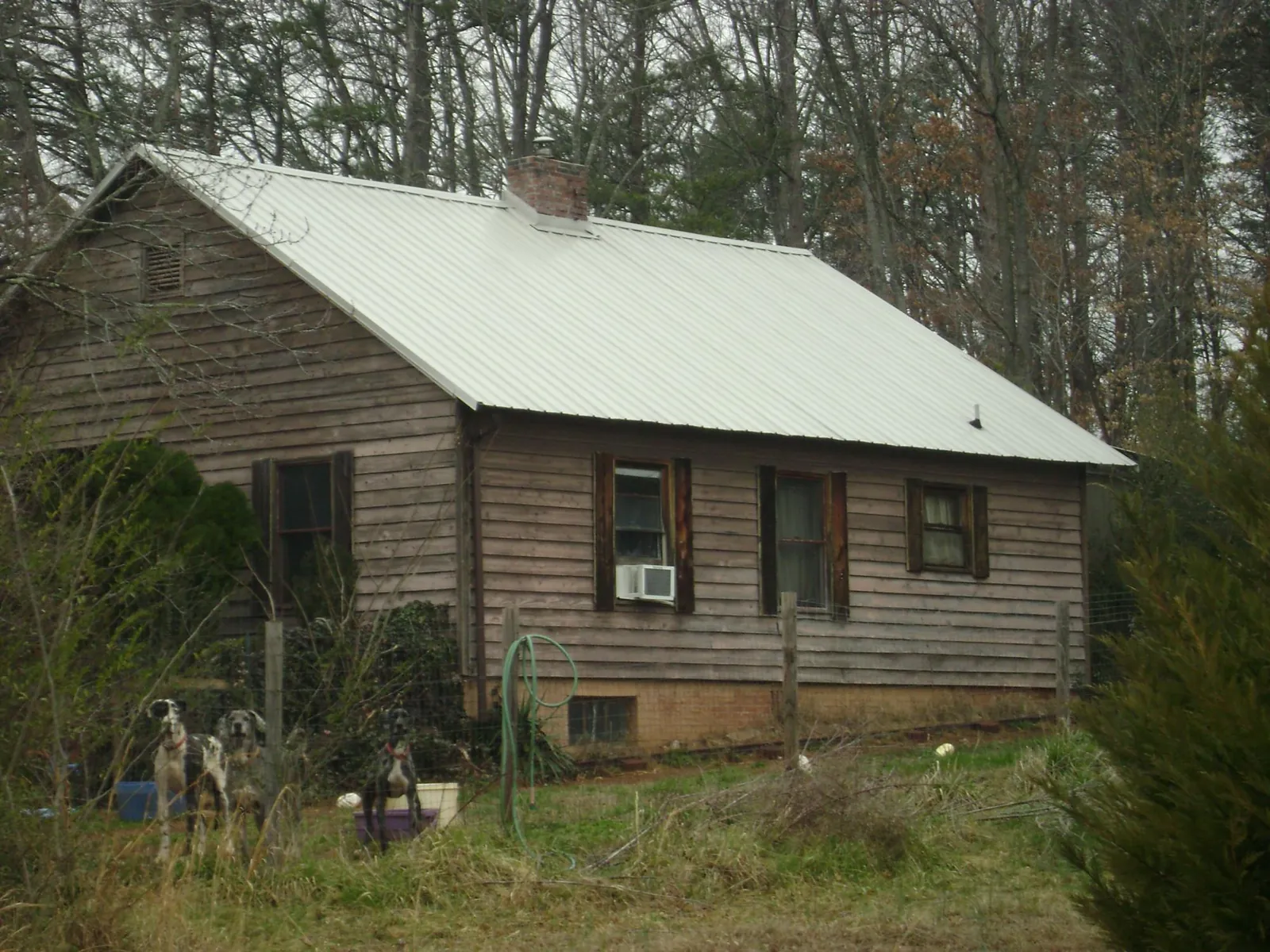 White metal roof on an old wood sided farmhouse, from a Metal Roof Installation job in Alexander City